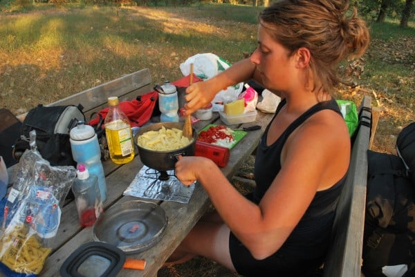Tara cooking tomato pasta at a picnic table in Italy.