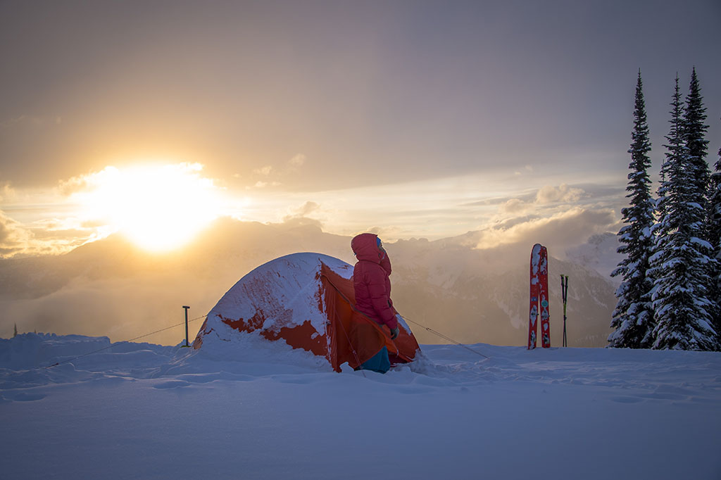 standing outside winter backcountry tent