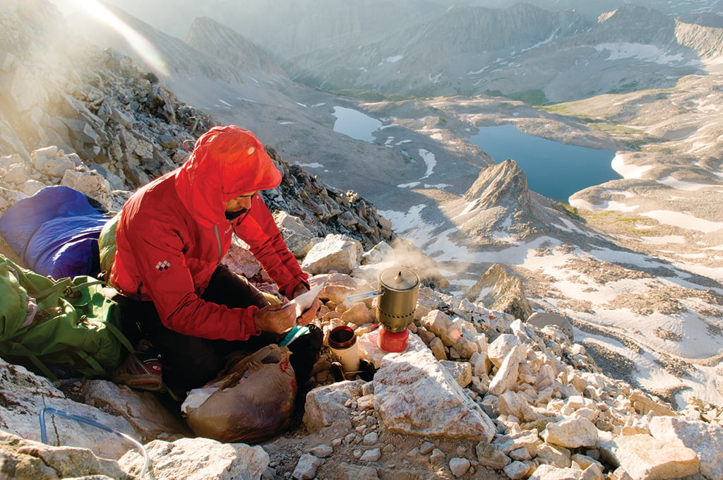 Josh Smith making coffee before breaking camp after a summit bivi on Capitol Peak, Maroon Bells Wilderness, White River National Forest, Marble, Colorado.