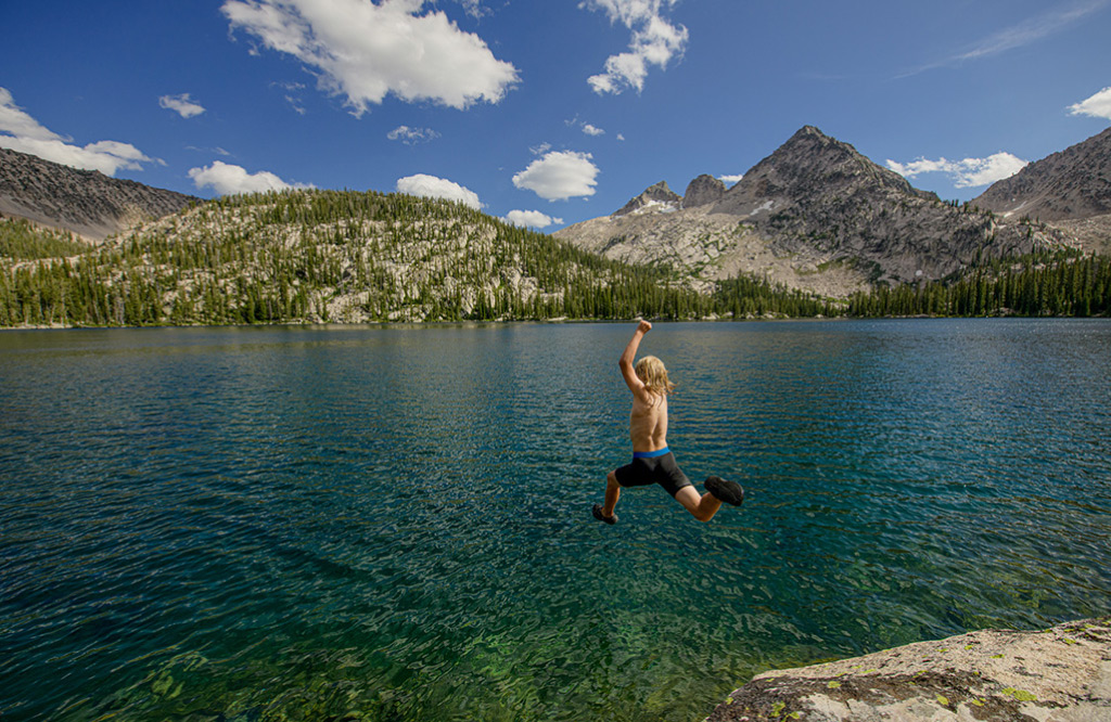 10 yo. Jasper Lee-Meyers launches off a rock into Toxaway Lake on a backpack along the Toxaway/Alice Lakes loop. Sawtooth Wilderness, Idaho.