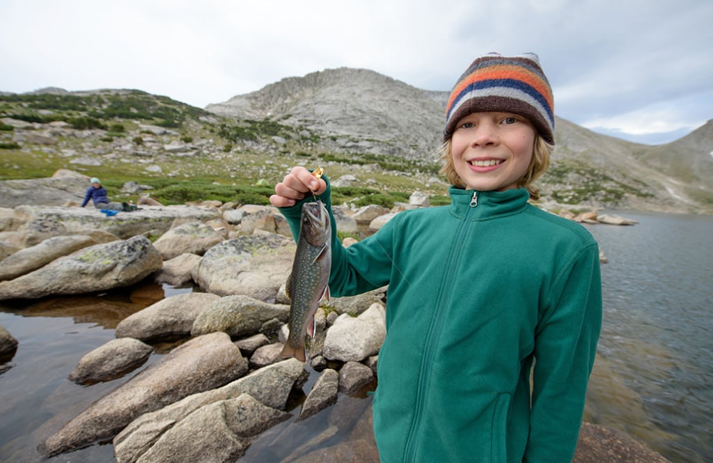 Boy holding freshly caught fish at Wind River