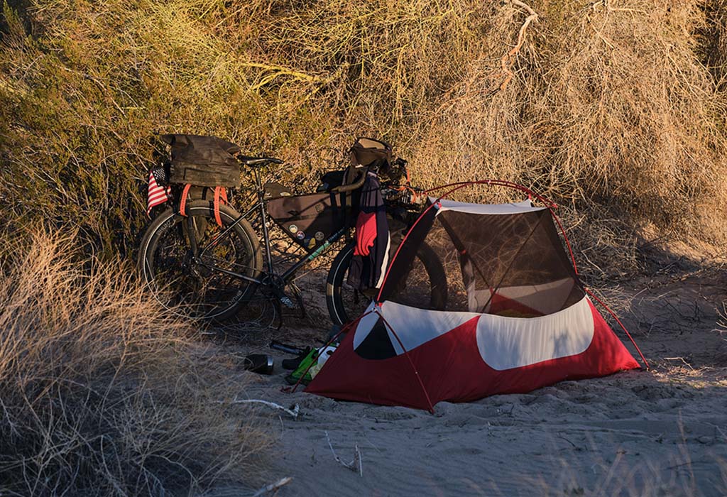 MSR tent standing next to bikepacking set up