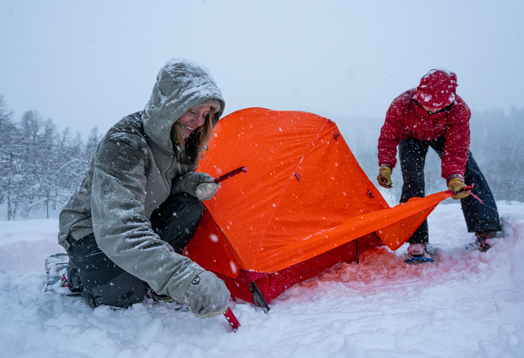 Snowshoers setting up MSR Access 2 tent in snow