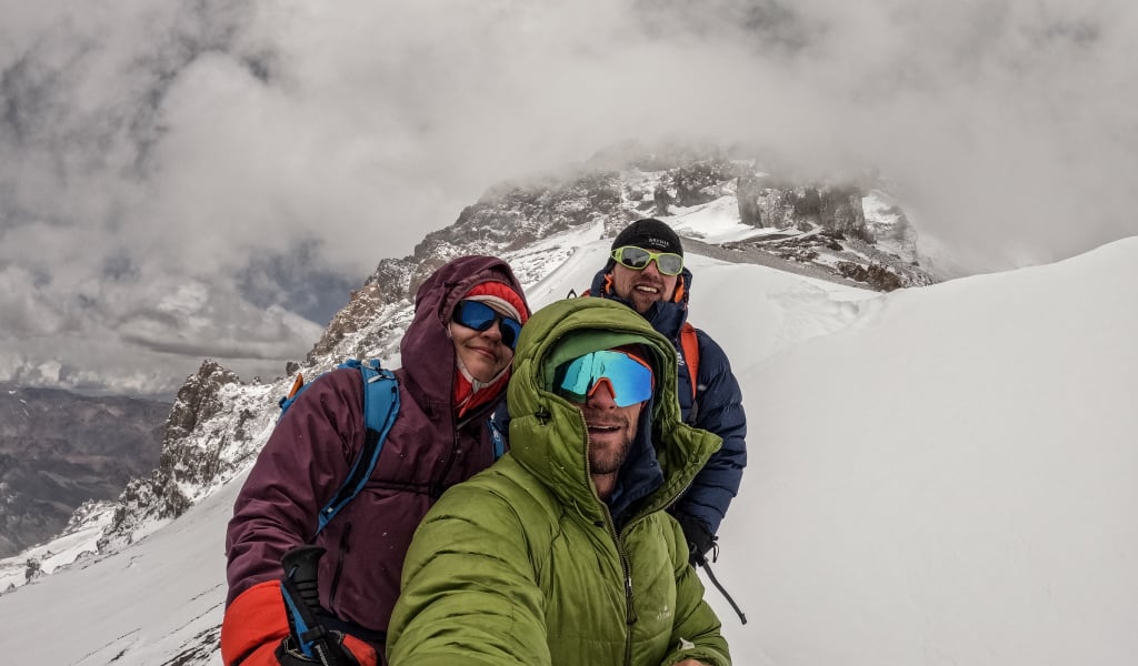 3 trekkers pose for selfie on snowy mountain 