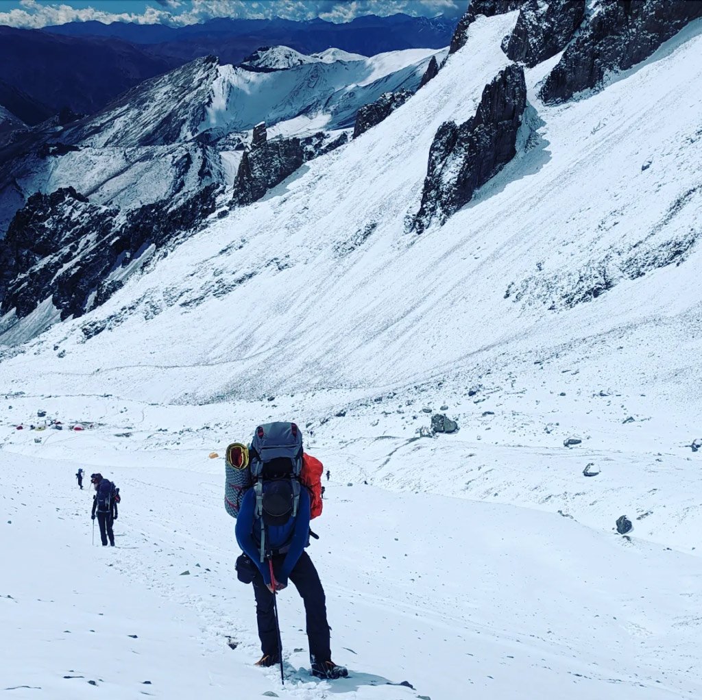 trekkers attempt to traverse across snowy slope