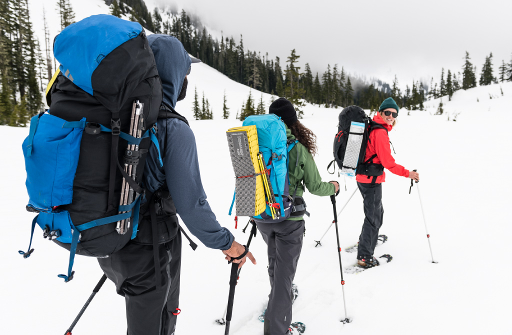 Snowshoers with loaded backpacks