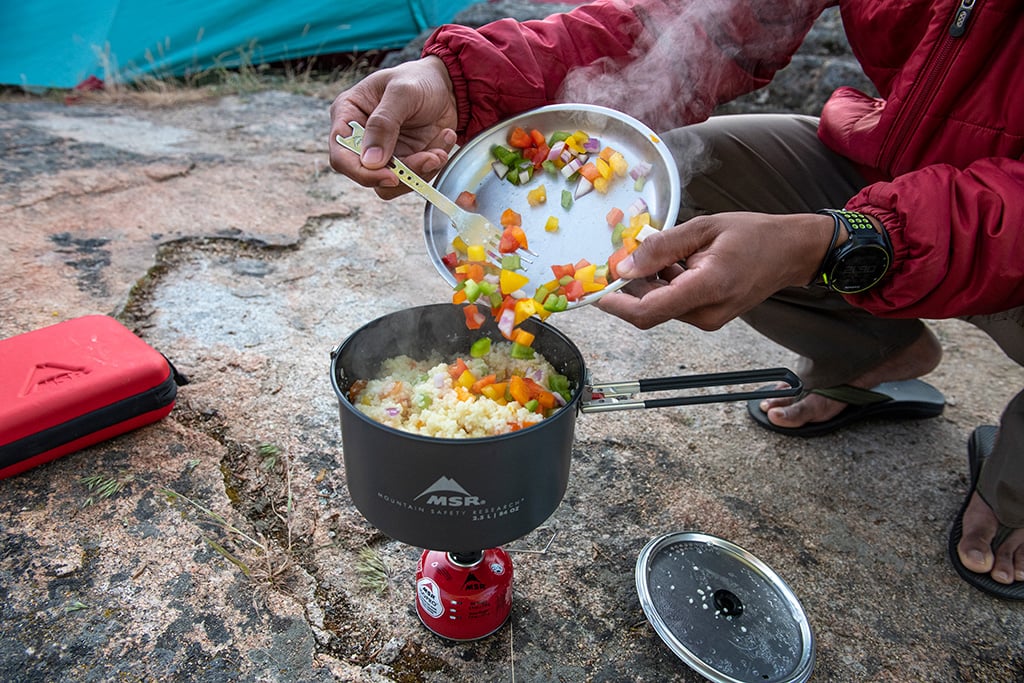 cooking veggies and rice in msr cookware on backpacking trip